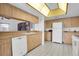 Kitchen with wood cabinets, white appliances and a built-in microwave at 4635 Bellemede Blvd, New Port Richey, FL 34655