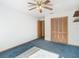 Bedroom with ceiling fan, closet, and blue carpet at 5085 Bone Ln, Brooksville, FL 34604
