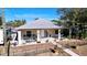 Tan house with a large front porch, a well-manicured lawn, and a metal fence at 6151 Louisiana Ave, New Port Richey, FL 34653