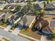 Aerial view of a neighborhood with mature trees, well-maintained lawns, and solar panels at 692 Challice Dr, Spring Hill, FL 34609