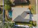 Aerial view of the home showcasing its pool, screened-in lanai, and landscaping at 692 Challice Dr, Spring Hill, FL 34609