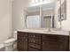 Well-lit bathroom featuring a dark wood vanity, neutral wall color, and a large framed mirror at 692 Challice Dr, Spring Hill, FL 34609