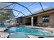 A delightful, private screened-in pool area with outdoor furniture and custom pool at 692 Challice Dr, Spring Hill, FL 34609