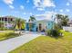 Bright blue home with a yellow trim, landscaping and a paved driveway at 7420 Hatteras Dr, Hudson, FL 34667