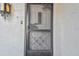 Front entrance with decorative screen door and exterior light at 8438 Luray Dr, Port Richey, FL 34668