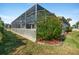 House exterior showcasing a lush landscape and screened patio at 8540 Caitlin Ct, Hudson, FL 34667