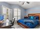 Well lit bedroom with a plush bed, a workspace, and window shutters at 9202 Fawn Crossings Ct, Tampa, FL 33626