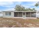 Rear view of house showcasing a screened patio and landscaping at 9240 Whitman Ln, Port Richey, FL 34668