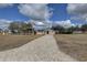 House with a green roof and a long driveway at 9376 Bearwalk Path, Weeki Wachee, FL 34613