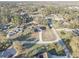 An aerial view of the home showcasing a large lot with mature trees and the surrounding neighborhood at 9376 Bearwalk Path, Weeki Wachee, FL 34613
