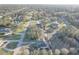 An aerial view of a quiet residential neighborhood with mature trees and lush green lawns surrounding each property at 9376 Bearwalk Path, Weeki Wachee, FL 34613
