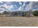 Backyard showcasing a home with a screened-in patio and pool, plus ample green space at 9376 Bearwalk Path, Weeki Wachee, FL 34613