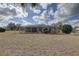A full view of the back of the home with a screened-in pool, patio, and large yard at 9376 Bearwalk Path, Weeki Wachee, FL 34613