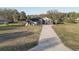 Beautiful tan home featuring an extra long paved driveway with a big yard at 9376 Bearwalk Path, Weeki Wachee, FL 34613