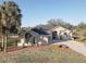 Stunning home featuring a paved driveway and a beautiful lawn with mature landscaping at 9376 Bearwalk Path, Weeki Wachee, FL 34613