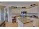 Bright kitchen features stainless steel appliances, white cabinets, and a functional island workstation at 9376 Bearwalk Path, Weeki Wachee, FL 34613