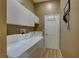 Functional laundry room with white cabinetry, a utility sink, washer, and dryer at 9376 Bearwalk Path, Weeki Wachee, FL 34613