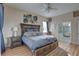 Well-lit main bedroom with wooden bed frame, hardwood floors, and access to the bathroom at 9376 Bearwalk Path, Weeki Wachee, FL 34613