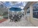Screened-in poolside patio featuring a dining table with umbrella and tiled flooring at 9376 Bearwalk Path, Weeki Wachee, FL 34613