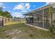 Private backyard featuring a screened-in patio and mature trees at 106 Aurora E St, Venice, FL 34285