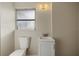 Compact bathroom featuring a toilet, vanity, and patterned window for privacy at 106 Aurora E St, Venice, FL 34285