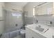 Bathroom with tub/shower combo, toilet, vanity, mirror, and tiled walls at 106 Aurora E St, Venice, FL 34285