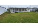 View of the home's backyard, showing overgrown grass and a detached structure at 12825 1St Isle, Hudson, FL 34667