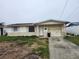 Single story home with damaged exterior and overgrown yard at 12825 1St Isle, Hudson, FL 34667