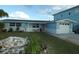 Light blue house with orange door and a nicely landscaped yard at 13410 Sunfish Dr, Hudson, FL 34667