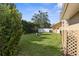 Well-maintained backyard with manicured lawn, mature landscaping, and a white privacy fence at 18242 Autumn Lake Blvd, Hudson, FL 34667