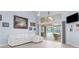 Bright living room with a white sectional, tile flooring, and sliding glass doors opening to a pool area at 18242 Autumn Lake Blvd, Hudson, FL 34667