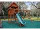 Backyard playground with slide, swings, and playhouse on a green rubber surface at 18242 Autumn Lake Blvd, Hudson, FL 34667