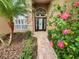 Front entry with a brick walkway and lush landscaping at 18912 Grand Club Dr, Hudson, FL 34667