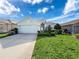 Single-story house with light teal exterior, two-car garage, and manicured lawn at 2518 Grey Dove Ct, Holiday, FL 34691