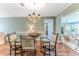 Bright dining room features a glass table, four chairs, and a beautiful chandelier at 2647 Royal Ridge Dr, Spring Hill, FL 34606