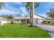 Front view of a single-story house with a palm tree and manicured lawn at 2647 Royal Ridge Dr, Spring Hill, FL 34606
