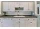 White kitchen with updated cabinets, granite counters, and built-in microwave at 2647 Royal Ridge Dr, Spring Hill, FL 34606