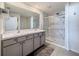 Bathroom with double vanity, marble shower, and grey cabinets at 3337 Autumn Amber Dr, Spring Hill, FL 34609