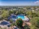 Aerial view of community pool, clubhouse, playground, and surrounding landscape at 3337 Autumn Amber Dr, Spring Hill, FL 34609