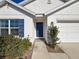 Front entrance with blue door, landscaping, and walkway at 3337 Autumn Amber Dr, Spring Hill, FL 34609