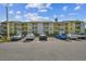 Front view of a yellow condo building with ample parking at 455 Alt 19 S # 163, Palm Harbor, FL 34683