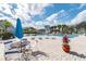 Relaxing pool area with tables, chairs, and umbrella at 455 Alt 19 S # 163, Palm Harbor, FL 34683