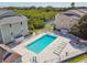 Community pool with lounge chairs and surrounding buildings at 455 Alt 19 S # 163, Palm Harbor, FL 34683