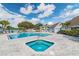 Community pool and spa with lounge chairs and patio area at 455 Alt 19 S # 163, Palm Harbor, FL 34683