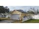Rear exterior view of the house showcasing a detached garage with solar panels and a white picket fence at 5031 6Th N Ave, St Petersburg, FL 33710