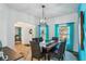 Bright dining room features a wooden table with wicker chairs and teal curtains at 5452 Queen Ave, Spring Hill, FL 34609