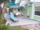 Relaxing outdoor patio area with a wooden deck, lounge chair, dining set, and charming cottage in the background at 641 Wilkie St, Dunedin, FL 34698