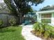 Landscaped backyard with a patio, dining set, lounge chair, and privacy fence at 641 Wilkie St, Dunedin, FL 34698