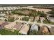 High aerial shows residential neighborhood; homes, streets, landscaping with open land and forest in the background at 14120 Whitecap Ave, Hudson, FL 34667