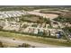 An aerial view shows houses with a lawn and garden, with a nearby lake and trees at 14120 Whitecap Ave, Hudson, FL 34667